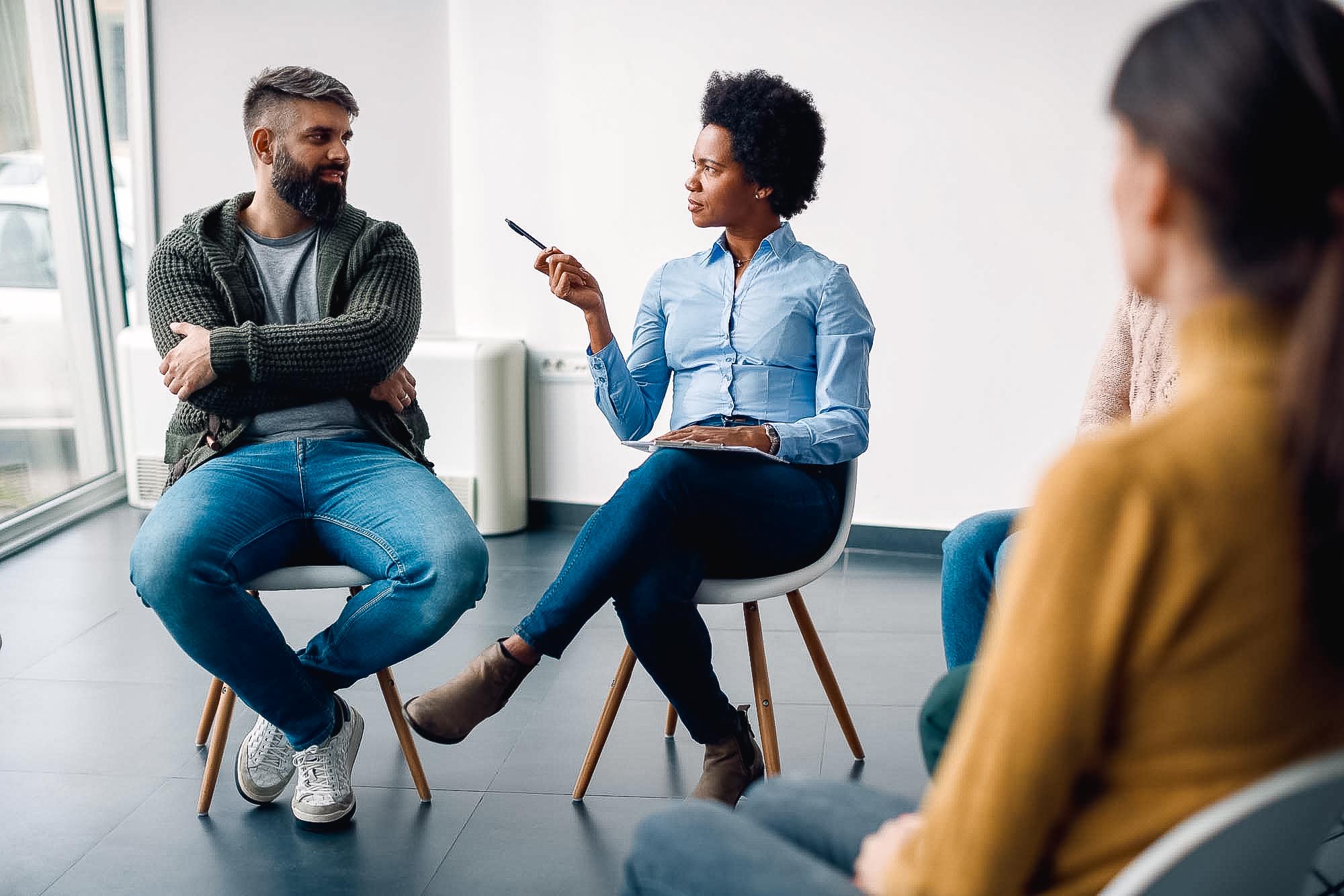African American mental health professional talking to a man during group therapy. man talking with therapist about anxiety